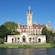 The entrance of Schwerin Castle overlooking a lake and surrounded by lush grounds